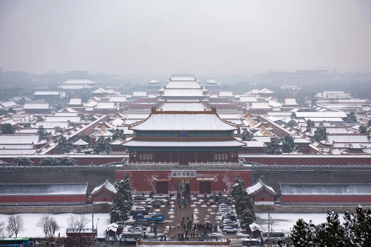 Snow on the yellow-tiled roofs of the Forbidden City seen from Jingshan Park on a grey January morning, Beijing