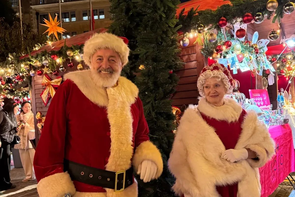 Costumed Santa and Mrs. Claus at a Shanghai outdoor Christmas market stall at night