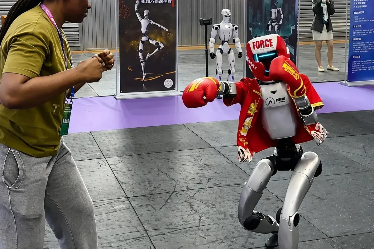 A guest watching a humanoid robot boxing demo on a CTX Huaqiangbei tour, Shenzhen